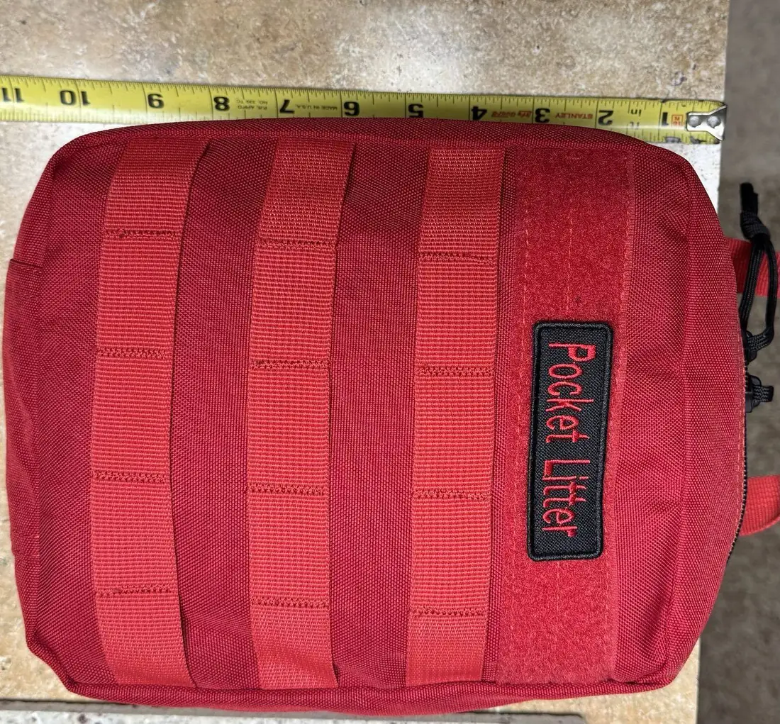 Red MOLLE carry bag for the Pocket Litter next to a tape measure
