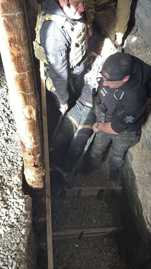 Rescuer in black pulling the Pocket Litter along the trench