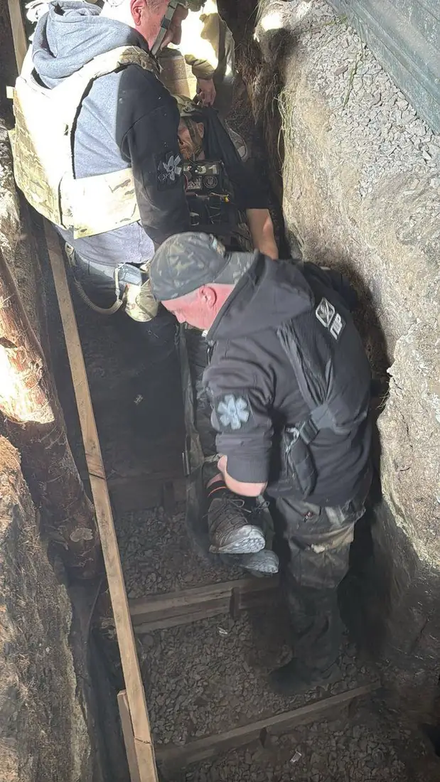Two rescuers working the Pocket Litter through a timber-lined section of trench
